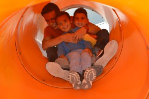 Alexandre escorrega com seus alunos no "playground" da escola. Foto de Carla Guarilha