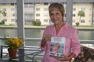 Heloisa, na casa de Eddie, em Miami, mostra com orgulho a capa do livro. Seu pai biológico morreu quando ela tinha 4 anos. Foto de Carla Guarilha