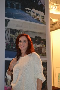 Atrás, um painel expondo um de seus trabalhos, no coquetel da Ornare. Foto de Carla Guarilha