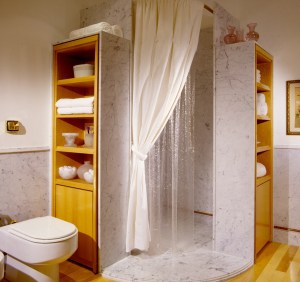 A cortina de plástico americana no banheiro de mármore fez enorme sucesso, dando inicio a sua marca registrada: simplicidade com sofisticação. Foto cortesia de Camilla Matarazzo