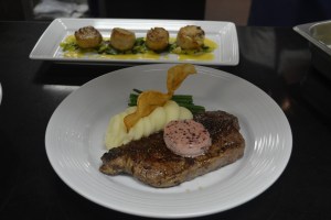 Prime N.Y Strip, um dos favoritos no menu, e atrás, vieiras com toque de caviar